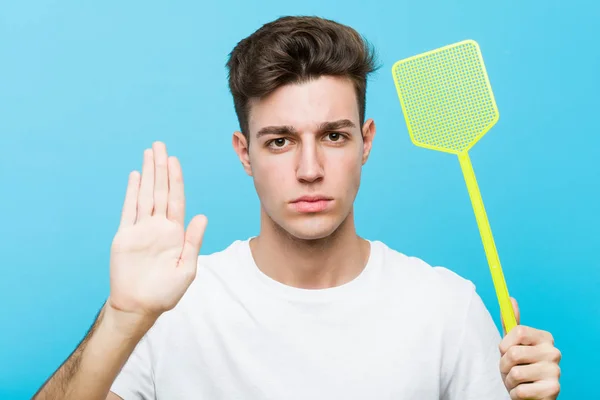 Joven Hombre Caucásico Sosteniendo Matamoscas Pie Con Mano Extendida Mostrando — Foto de Stock