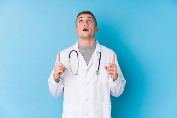 Jovem Branco Médico Homem Apontando Cabeça Com Boca Aberta — Fotografia de Stock