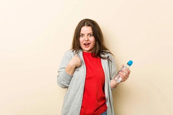 Young Size Curvy Woman Holding Water Bottle Surprised Pointing Himself — Stock Photo, Image