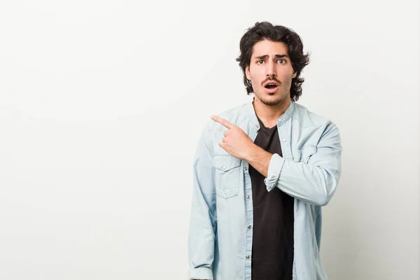 Jovem Homem Bonito Contra Fundo Branco Apontando Para Lado — Fotografia de Stock