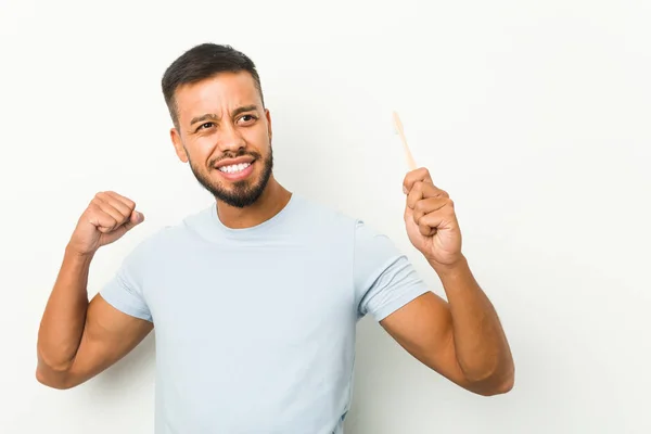 Young South Asian Man Holding Toothbrush Raising Fist Victory Winner — Stock Photo, Image