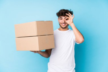 Genç Arap adam kutuları tek başına tutuyor. Heyecanlı. Gözünü dört aç..