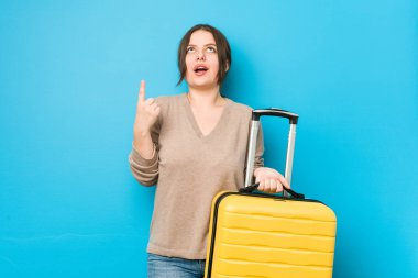 Elinde bavul tutan, ağzı açık genç bir kadın..