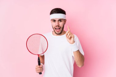 Badminton oynayan genç beyaz bir adam bir fikri, ilham verici bir konsepti var..