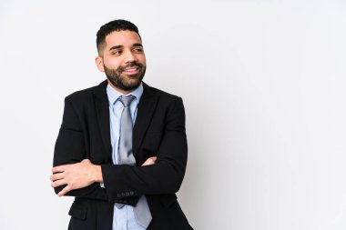 Beyaz bir geçmişi olan genç Latin bir iş kadını kollarını kavuşturarak sırıtıyor..