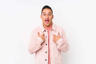 Yalnız poz veren genç Latin adam parmağını göstererek şaşırdı ve gülümsedi..