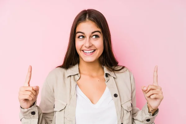 Joven Mujer Caucásica Posando Fondo Rosa Indica Con Ambos Dedos —  Fotos de Stock