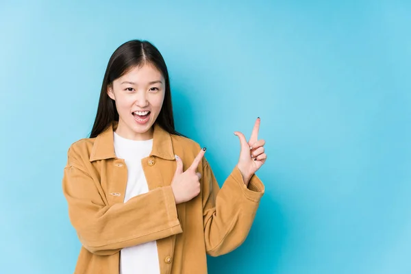 Jonge Chinese Vrouw Poseren Een Blauwe Achtergrond Geïsoleerd Wijzend Met — Stockfoto
