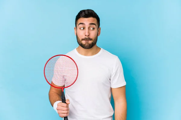 Joven Hombre Guapo Jugando Bádminton Aislado Confundido Siente Dudoso Inseguro — Foto de Stock