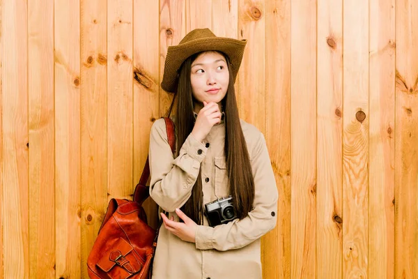 年轻的中国女旅行家带着怀疑和怀疑的表情侧视着 — 图库照片