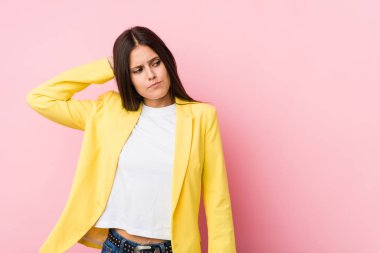 Genç iş kadını başının arkasına dokunuyor, düşünüyor ve seçim yapıyor.