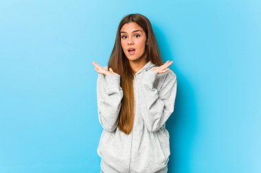 Young sporty woman surprised and shocked.