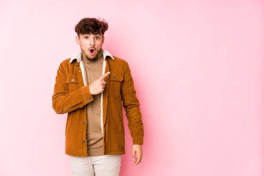 Pembe arka planda poz veren genç bir Arap.