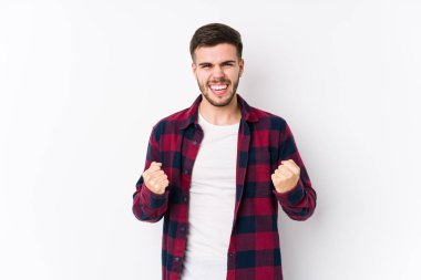 Beyaz arka planda poz veren beyaz tenli genç bir adam yalnız, gamsız ve heyecanlı. Zafer konsepti.