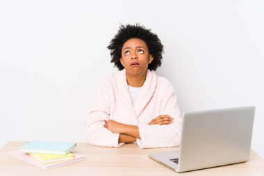 Orta yaşlı Afrikalı Amerikalı kadın evde çalışıyor. Sürekli tekrarlanan bir görevden yorulmuş..