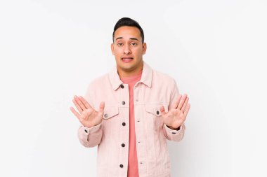 Genç latin adam dışlanmış poz veriyor. İğrenme hareketi gösteren birini reddediyor..