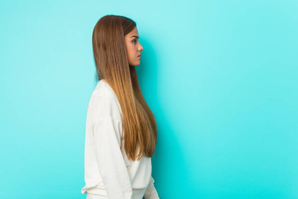 Young slim woman gazing left, sideways pose.