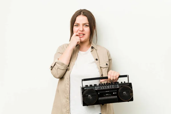 年轻的卷曲女人拿着复古收音机咬指甲 神经紧张 非常焦虑 — 图库照片