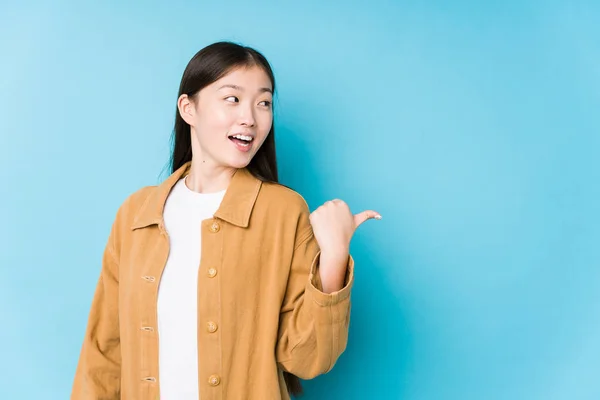 Young Chinese Woman Posing Blue Background Isolated Points Thumb Finger — Stock Photo, Image