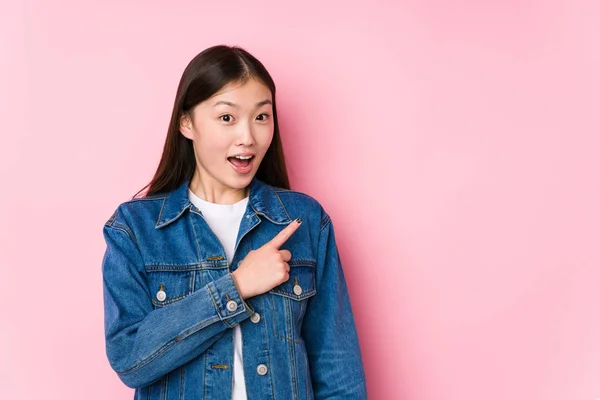 Young Chinese Woman Posing Pink Background Isolated Smiling Pointing Aside — 스톡 사진