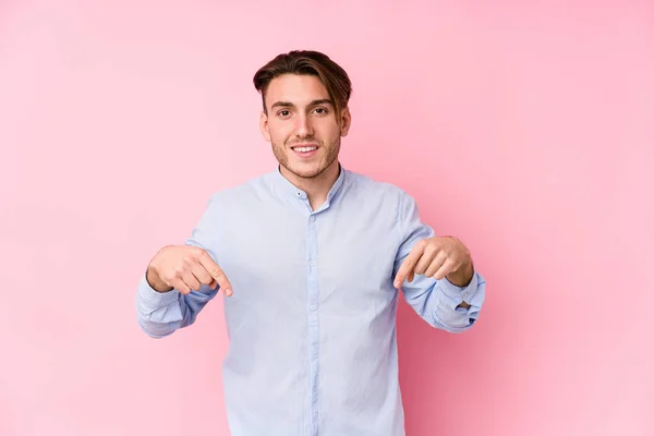 Joven Hombre Caucásico Posando Fondo Rosa Aislado Apunta Hacia Abajo — Foto de Stock