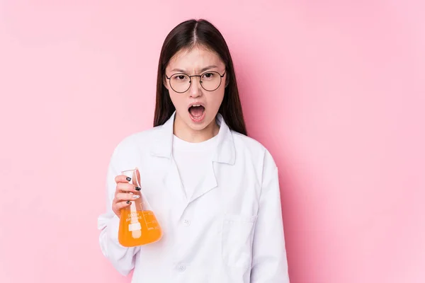 Young chinese scientific woman isolated screaming very angry and aggressive.