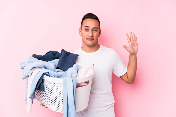 Ung Latinamerikansk Man Plockar Upp Smutsiga Kläder Isolerad Ler Glad — Stockfoto