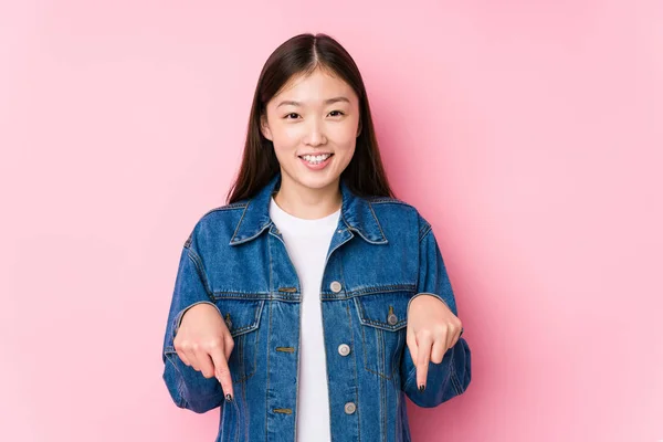 Jonge Chinese Vrouw Poseren Een Roze Achtergrond Geïsoleerde Punten Naar — Stockfoto
