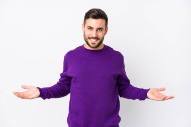 Beyaz arka planda beyaz tenli genç bir adam hoş bir ifade sergiliyor..