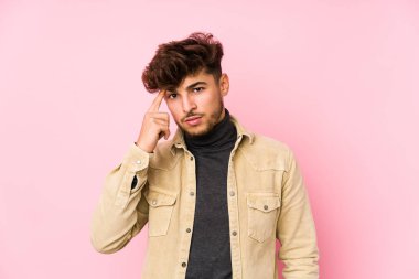 Arka planda yalnız poz veren genç bir Arap adam işaret parmağıyla hayal kırıklığı jesti yapıyor..