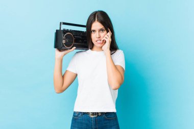 Kafkasyalı genç bir kadın elinde Guetto tabancasıyla tırnak yiyor, gergin ve çok endişeli..