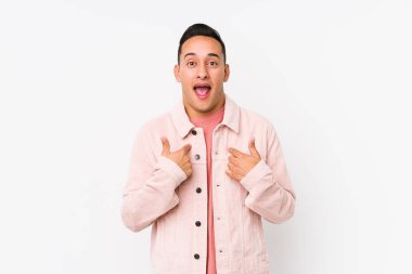 Yalnız poz veren genç Latin adam parmağını göstererek şaşırdı ve gülümsedi..