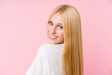 Pembe arka planda soyutlanmış genç sarışın kadın yüzü.