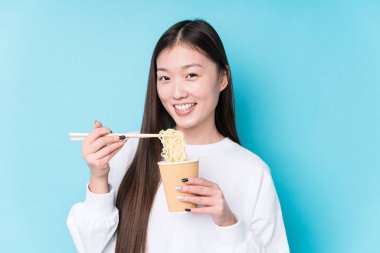 Genç Japon kadın erişte yiyor.