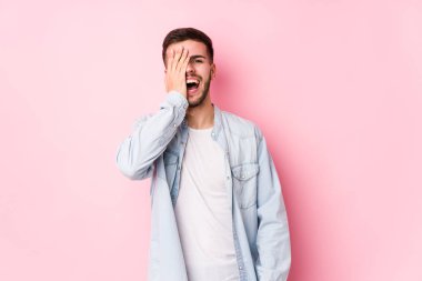 Pembe arka planda poz veren beyaz bir iş adamı.