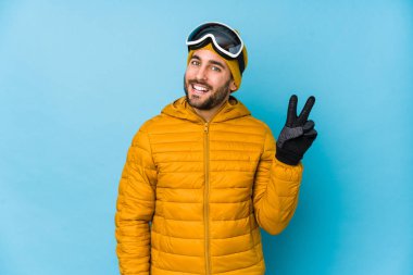 Genç kayakçı beyaz adam neşeli ve kaygısız izole edilmiş parmaklarıyla barış sembolü gösteriyor..