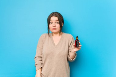 Buharlaştırıcı tutan genç kıvrımlı kadın omuzlarını silker ve gözleri açık kalır..