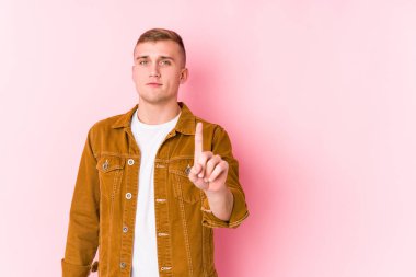 Kafkasyalı genç bir adam izole edilmiş. Bir numarayı parmağıyla gösteriyor..