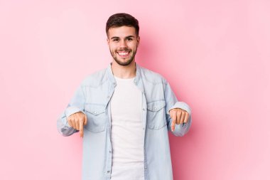 Pembe arka planda poz veren beyaz bir iş adamı.