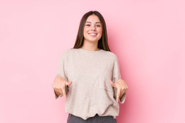 Genç beyaz kadın izole noktaları parmaklarıyla aşağı çekiyor, olumlu bir his..