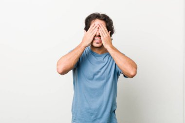 Beyaz bir geçmişi olan genç yakışıklı bir adam elleri ile gözlerini kapatıyor, geniş bir gülümsemeyle bir sürpriz bekliyor..