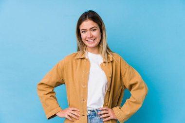 Genç beyaz kadın kendine güveniyor, ellerini kalçasında tutuyor..