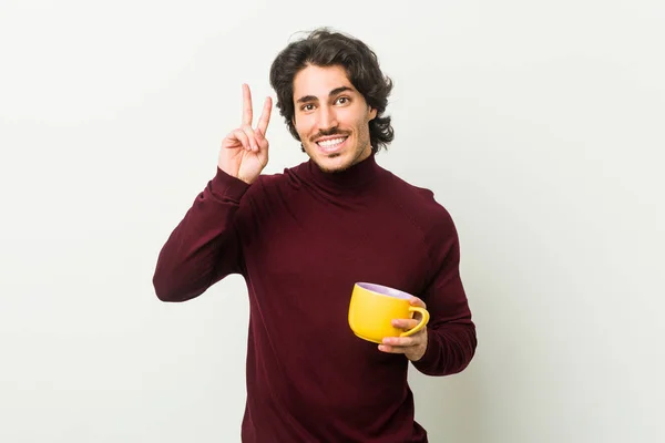 Joven Hombre Caucásico Sosteniendo Una Taza Café Mostrando Signo Victoria — Foto de Stock