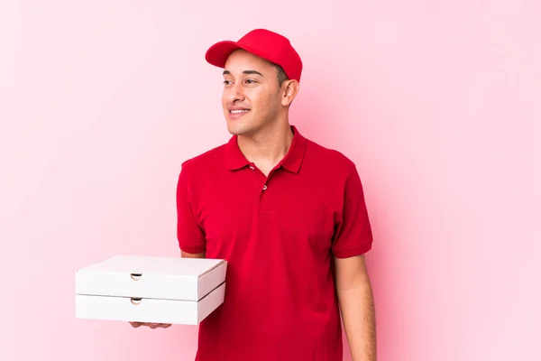 Young Pizza Delivery Latin Man Isolated Looks Aside Smiling Cheerful — ストック写真