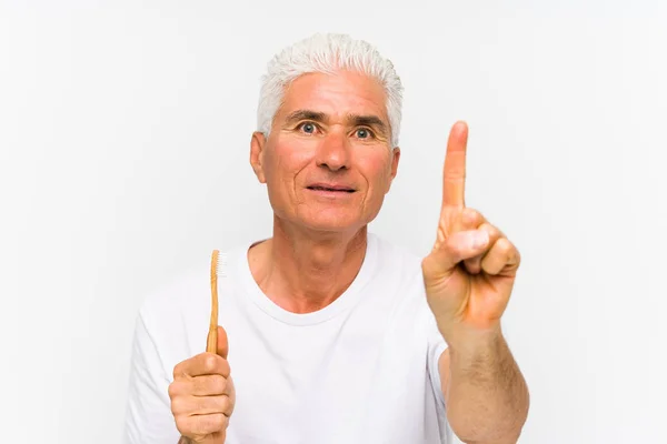 Homem Caucasiano Sênior Segurando Uma Escova Isolada Mostrando Número Com — Fotografia de Stock