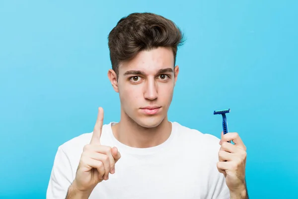 Young Caucasian Man Holding Razor Blade Showing Number One Finger — Stock Photo, Image