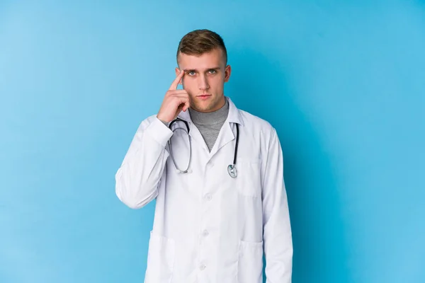 Jovem Homem Médico Caucasiano Apontando Templo Com Dedo Pensando Focado — Fotografia de Stock