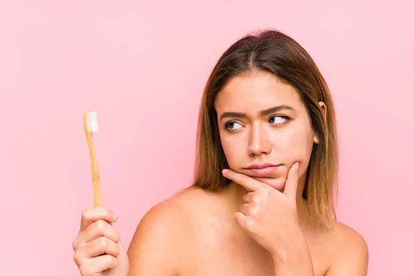 Mujer Caucásica Joven Sosteniendo Cepillo Dientes Aislado Mirando Hacia Los — Foto de Stock