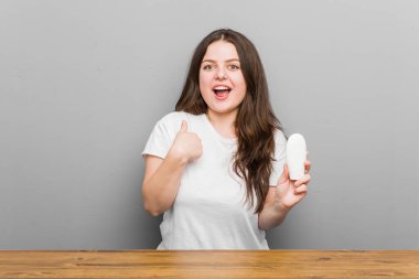 Elinde nemlendirici tutan genç ve cüsseli bir kadın kendini gösterip gülümseyerek şaşırdı..