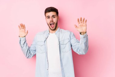 Pembe arka planda poz veren beyaz bir iş adamı.